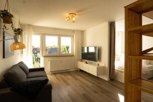 a living room with a couch and a television at Auenblick -Natur genießen, Leipzig erleben in Leipzig