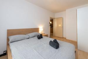 a bedroom with a large bed with two bags on it at Steps from Chantarella Lift - Skies Dream in St. Moritz