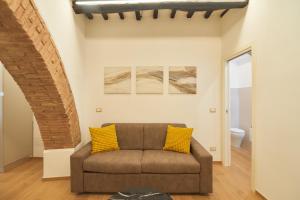 a living room with a brown couch and yellow pillows at AM13 - Design retreat in Perugia +25 photos