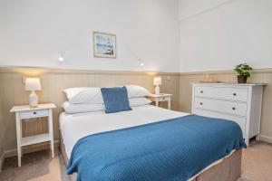 a bedroom with a bed with a blue blanket at Elegant 3BD Escape - Perfect Central Location in Oban