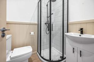 a bathroom with a shower and a toilet and a sink at Elegant 3BD Escape - Perfect Central Location in Oban