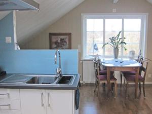 a kitchen with a sink and a table with chairs at 4 person holiday home in Romelanda-By Traum in Romelanda