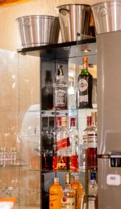 a shelf filled with lots of bottles of alcohol at Apart Hotel Caminho do Trem in São João del Rei