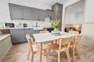 a kitchen and dining room with a white table and chairs at Luxury 3BD Central Apt with Tower & Seaviews in Oban +11 photos