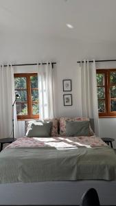 une chambre avec un grand lit avec deux fenêtres dans l'établissement Home apartment Konopiště,  14 autres photos