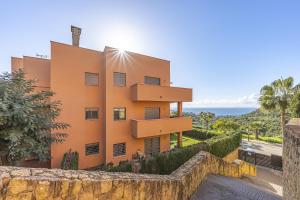 Un edificio naranja con el océano al fondo. en Rock Bay II 2456 SEA VIEW, en Sotogrande