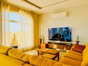 a living room with a couch and a flat screen tv at Pitt House in Nadur