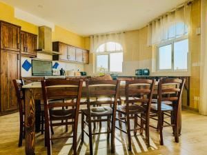 a kitchen with a table and chairs in a kitchen at Pitt House in Nadur +16 photos
