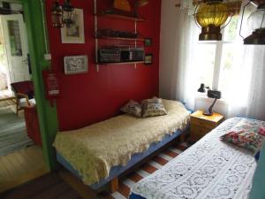 a bedroom with two beds and a red wall at Gula Villan in Maxmo