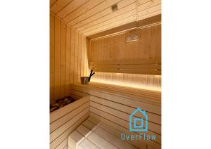 een houten sauna met een bank erin bij Coast Apartment with Sauna & Gym, 5 Min to Baltic Sea & Polsat Plus Arena in Gdańsk +34 foto's