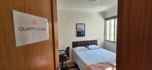 a small bedroom with a bed and a window at Quarto Clara in Sao Paulo