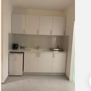 a kitchen with white cabinets and a sink at Romy boutique netanya in Netanya