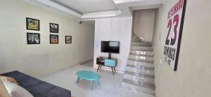 a living room with a couch and a tv and stairs at Quarto Clara in Sao Paulo