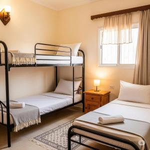 una habitación con dos literas y una ventana en Gamandy Hostel, en Luxor