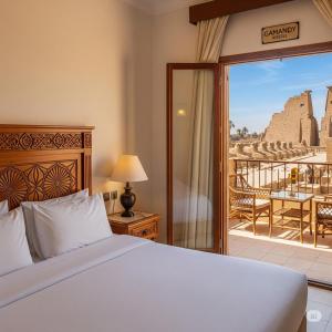Un dormitorio con una cama y un balcón con vistas. en Gamandy Hostel, en Luxor