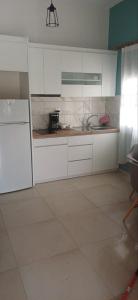 a kitchen with white cabinets and a counter top at Acheron Flow by ΜΡS in Chóïka