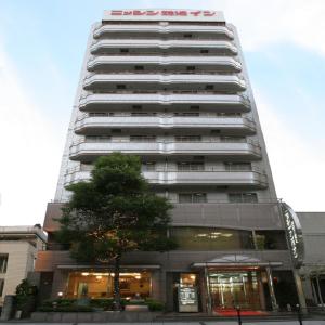 a tall building with a clock on the front of it at Nisshin Namba Inn in Osaka
