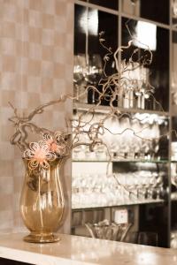 un vaso d'oro con dei fiori sul tavolo. di Hotel La Passionaria a Mariánské Lázně