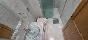 a bathroom with a toilet and a glass shower at Quarto Clara in Sao Paulo