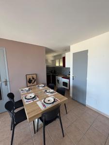a dining room with a table and chairs and a kitchen at Apartment T2 with sea view in Saint Cyprien 50 m from the beach, parking in Saint Cyprien Plage