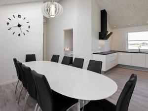a white dining room with a white table and black chairs at Luxury Spa Retreat in Lokken - By Traum Ferienwohnungen in Løkken