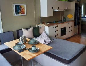 un piccolo soggiorno con un tavolo e una cucina di Traumhaus-auf-dem-Wasser-Modernisiertes-Hausboot-13-x-4-m a Kützkow Altre 15 foto