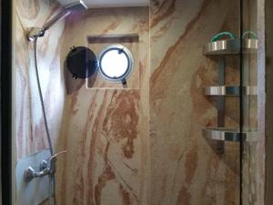bagno con specchio e doccia di Traumhaus-auf-dem-Wasser-Modernisiertes-Hausboot-13-x-4-m a Kützkow