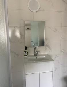 a white bathroom with a sink and a mirror at Romy secrets in Netanya