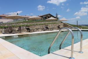 uma piscina com cadeiras e guarda-sóis em Relais Pugliano em Monterappoli