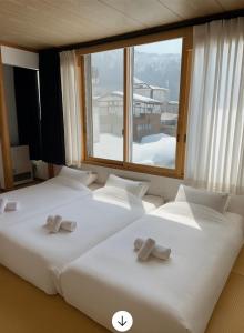 three beds in a room with a large window at Snow Palace Nozawa in Nozawa Onsen