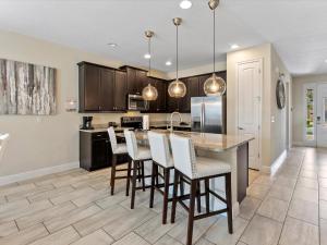 una cucina con una grande isola con sgabelli da bar di Family Friendly Home With Private Pool, Game Room, Waterpark & Resort Access Near Disney At Encore Resort - 7638Wi a Kissimmee