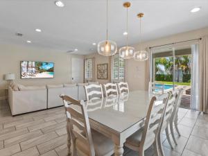 una sala da pranzo con tavolo e sedie di Family Friendly Home With Private Pool, Game Room, Waterpark & Resort Access Near Disney At Encore Resort - 7638Wi a Kissimmee