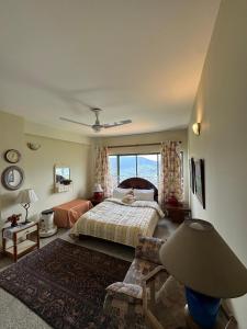 a bedroom with a bed and a large window at Starry Nights by Demanchi in Bhurban
