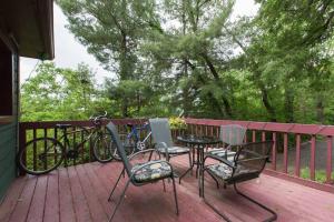 a patio with a table and chairs and bikes on a deck at Private Green Cottage near downtown in Asheville
