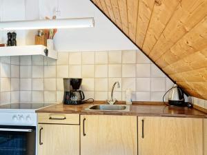 une cuisine avec un évier et une cuisinière dans l'établissement 4 person holiday home in Nexø-By Traum, à Balke