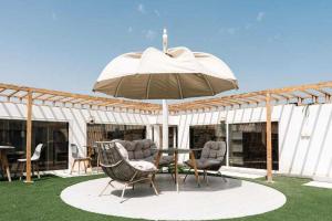 a patio with a table and chairs and an umbrella at Sunday Gateway Jeddah Formerly Beach Garden Hotel in Jeddah
