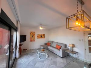 a living room with a couch and a chandelier at Las Colinas Beach in Manilva
