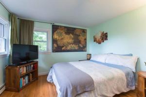 a bedroom with a bed and a flat screen tv at Private Green Cottage near downtown in Asheville