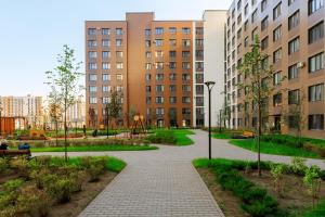 a walkway in a city with buildings and a playground at Красивые новые апартаменты in Astana