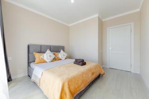 a bedroom with a large bed with orange pillows at Красивые новые апартаменты in Astana