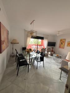 a living room with a glass table and chairs at Las Colinas Beach in Manilva