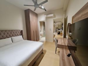 ジョホールバルにあるParadigm Residence Johor Bahruのベッドと天井扇風機のある寝室