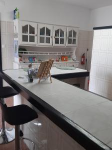 a kitchen with a counter with two chairs on it at Casa vicente in Santa Cruz das Flores +154 photos