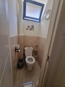 a small bathroom with a toilet and a window at הבית בפיקא. צמוד לרמבם in Tiberias