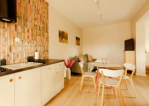 a kitchen and living room with a table and chairs at Monic Apart Ogród in Mechelinki
