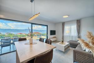 a living room with a table and a large window at Mateas Seaview Patio in Slatine
