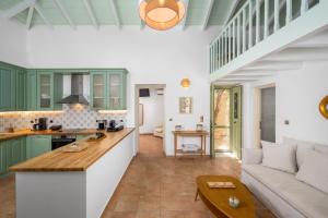 a kitchen and living room with green cabinets and a couch at Villa Theoni in Halki