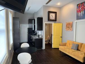 ニューオーリンズにあるModern Condo 3のリビングルーム(ソファ付)と黄色のドア