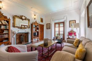 un soggiorno con un divano e un tavolo di Villa Elvira, exclusive Pool and Gardens in the heart of Sevilla a Siviglia