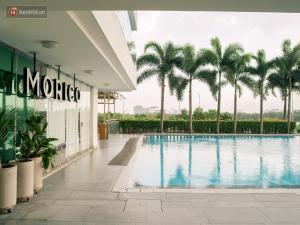 a hotel lobby with a swimming pool and palm trees at Căn hộ cao cấp Diamond Island Luxury Apartment in Ho Chi Minh City